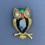 Owl Brooch with rainbow rhinestones, blue crystal, green and red enamel, golden metal, diameter 32 mm, length 55 mm