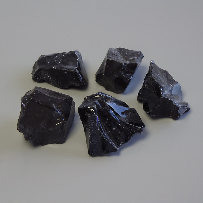 Unpolished volcanic obsidian souvenir stone — dimensions 30-46 x 23-35 mm (+/-); packaging 100 g (price per 100 g).