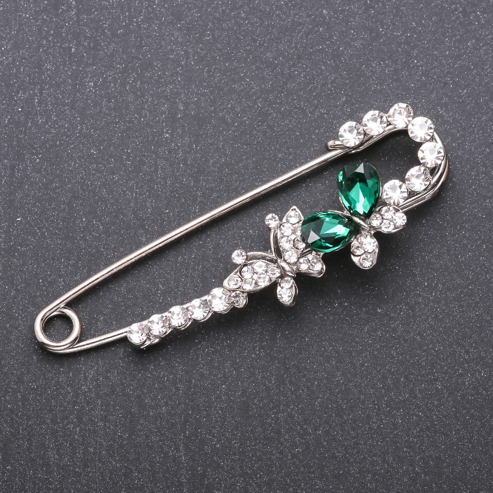 Brooch-pin with green crystals 76×23 mm white metal