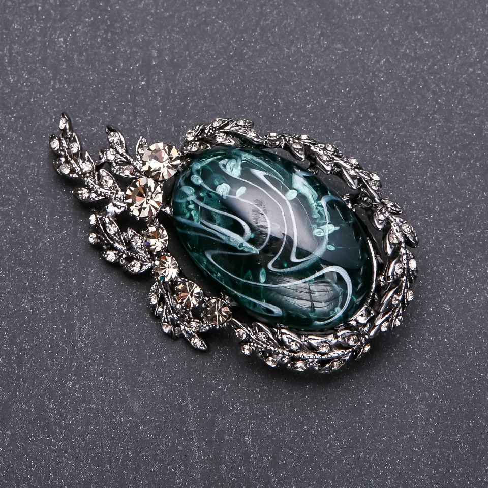 Brooch with gray rhinestones and emerald cabochon, 64×38 mm gray metal