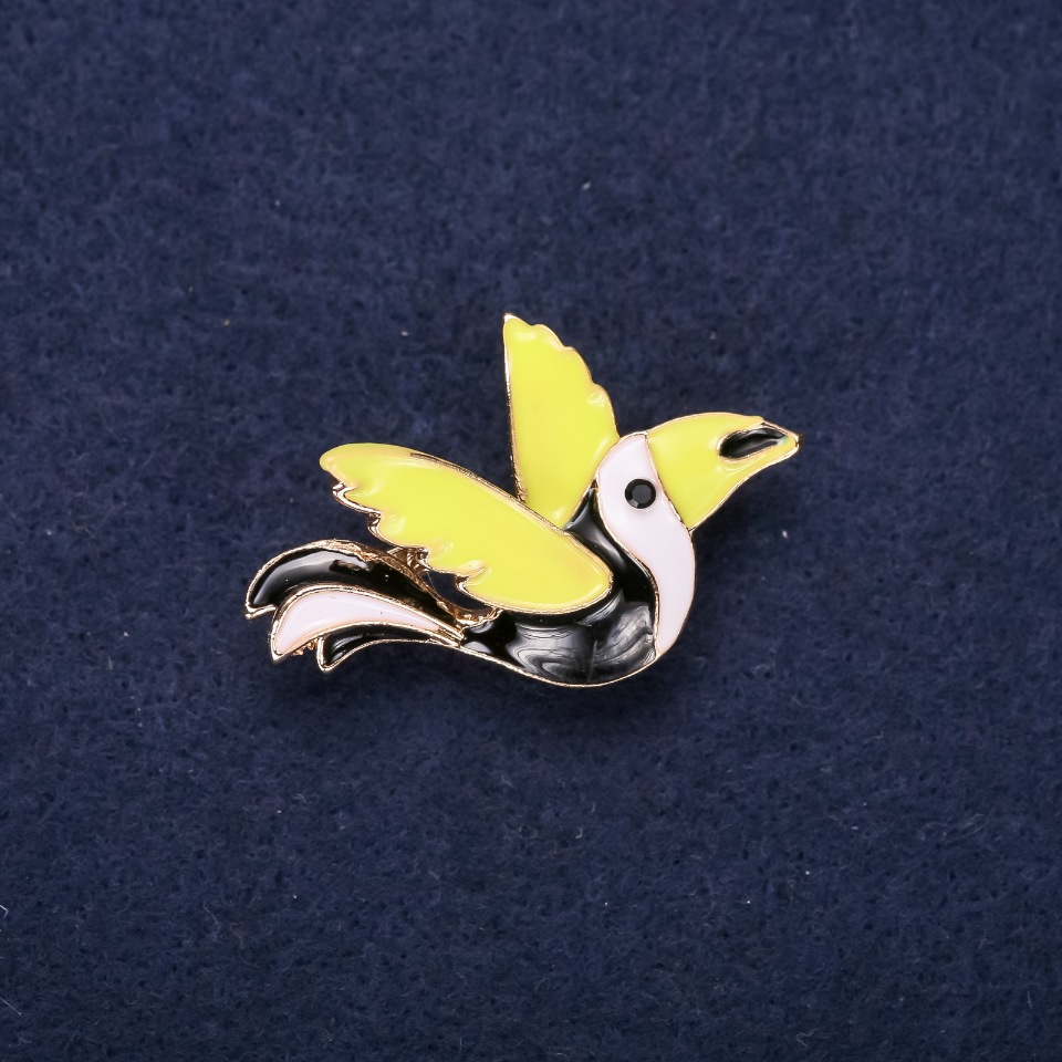 Bird-shaped enamel brooch in black, white, and green