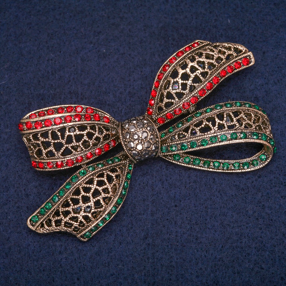 Bow Brooch with green, red, and gray rhinestones, antique gold-tone metal, 38×72 mm