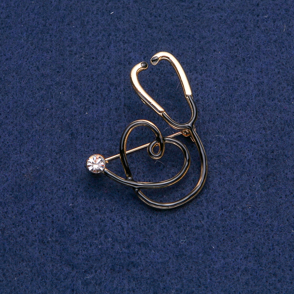 Brooch: Black stethoscope with heart, white stone, gold-tone metal 43×33 mm