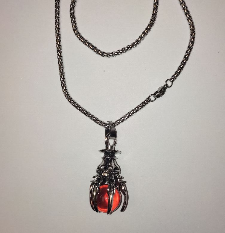 Pendant 'Ball in the Paw' orange 40x18 mm on a chain, length about 70 cm, silver-toned metal
